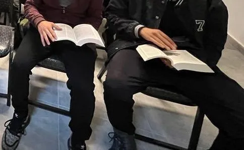 Two young men reading their Bibles