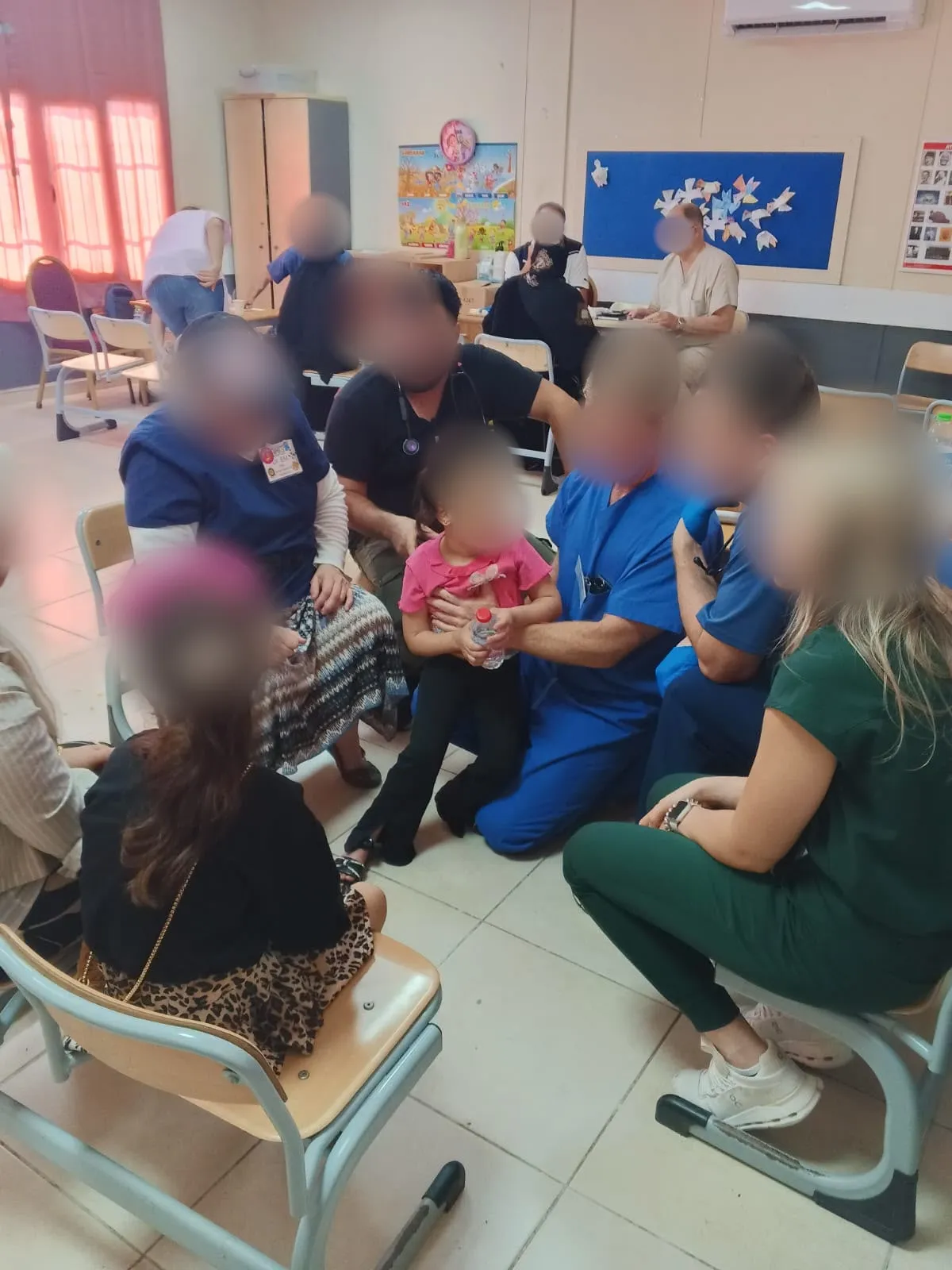 Members of a medical team caring for a little girl and her family in a classroom clinic