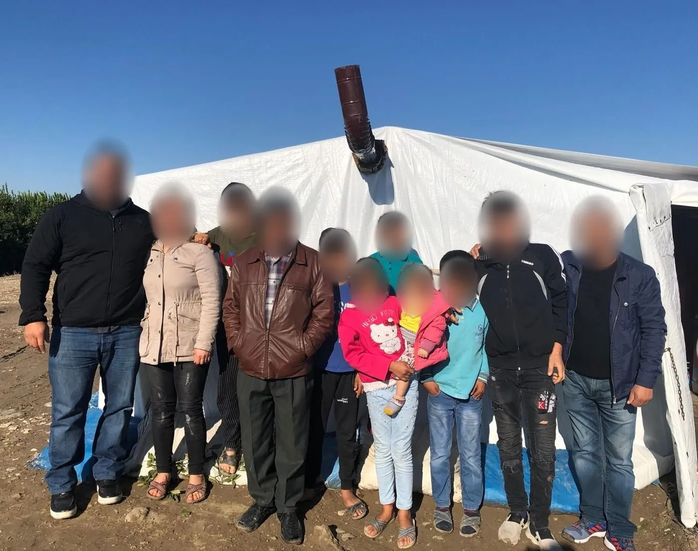 Our team with a refugee family in front of their tent near Adana